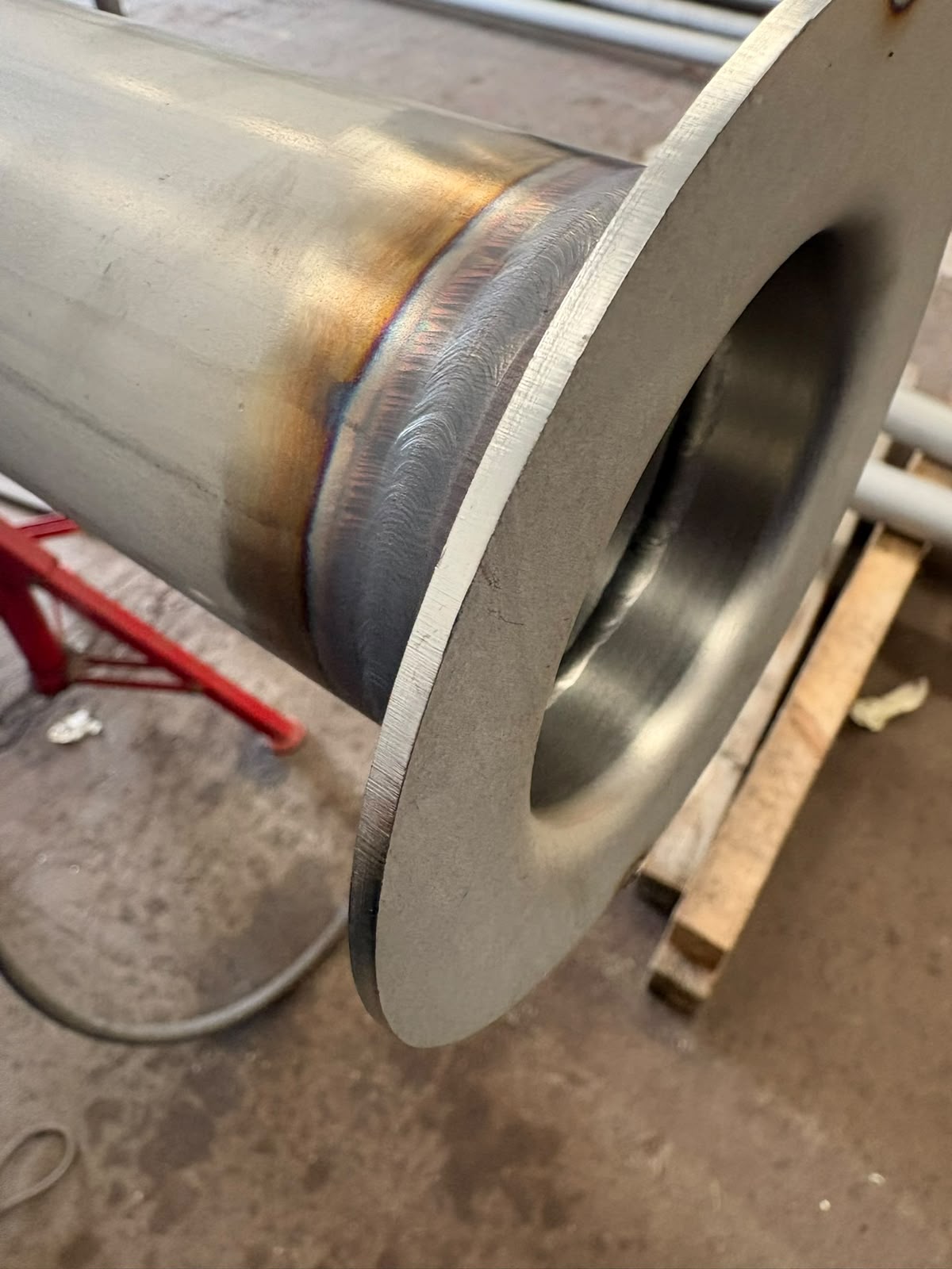 Machined stainless flanged pipe section on the bench